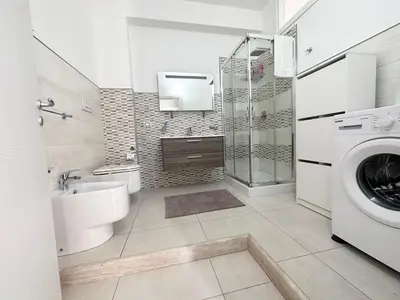 a bathroom with a toilet sink and a washing machine at Mare Blu Apartament in Balestrate
