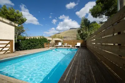 a pool with a wooden fence next to a house at Villa Paradiso in Castelluzzo