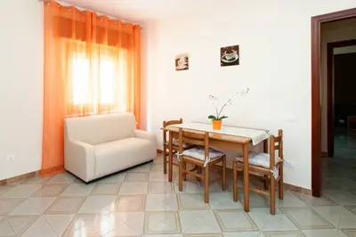 a dining room with a table and a chair at Il Terrazzo Di Oleandri in Bagheria