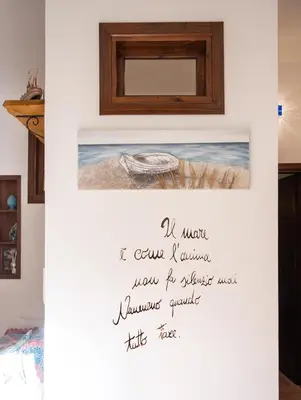 a sign on a wall in a room with a picture at Villa Carilù in Altavilla Milicia