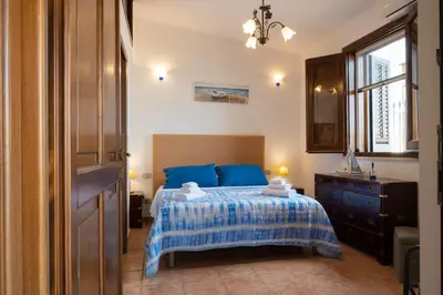 a bedroom with a bed and a dresser and a window at Villa Carilù in Altavilla Milicia