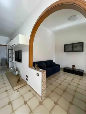a living room with a blue couch and an archway at Villa Nasus in Carini