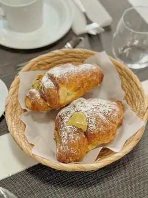 two pastries with powdered sugar on them in a basket at Serendipity room & relax in Palermo