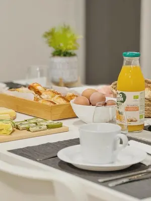 a table with bread and a bottle of orange juice and a cup of coffee at Serendipity room & relax in Palermo