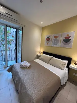 a bedroom with a large bed and a large window at A casa di Alli in Palermo