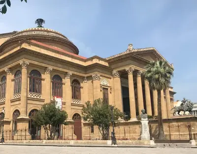 a large building with a statue in front of it at A casa di Alli in Palermo