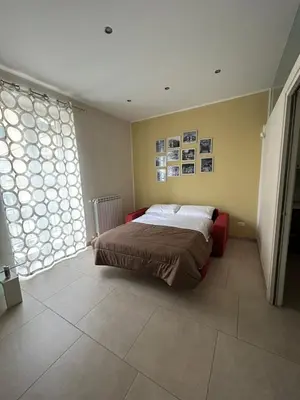 a bedroom with a bed and a large window at A casa di Alli in Palermo