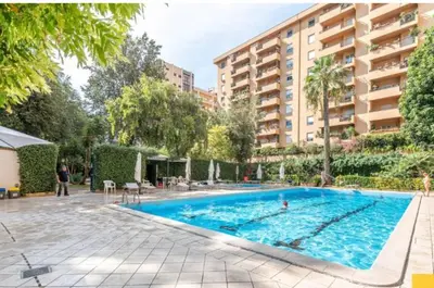 a large swimming pool in front of a building at Cleotto residence case vacanza in Palermo