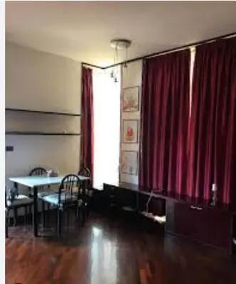 a room with a table and a red curtain at Cleotto residence case vacanza in Palermo