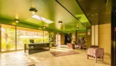 a living room with green walls and a table and chairs at Cleotto residence case vacanza in Palermo