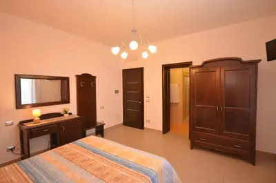 a bedroom with a bed and a dresser and a mirror at Baia Santa Margherita B&B in Castelluzzo