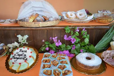 a table with various pastries and other pastries on it at Baia Santa Margherita B&B in Castelluzzo
