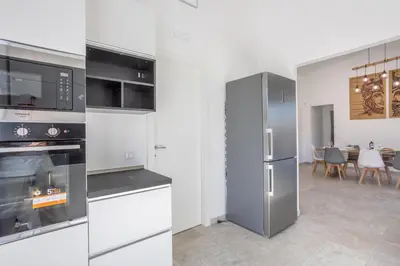 a kitchen with stainless steel appliances and a dining room at Villa Aurora in Balata di Baida