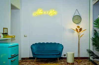 a blue chair in a room with a sign on the wall at Alba e i Mori in Palermo