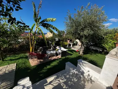 a view of a yard with grass and trees at Villetta dei Tramonti in Trappeto