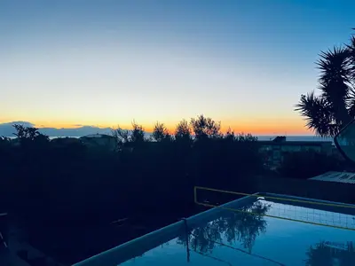 a swimming pool with a sunset in the background at Villetta dei Tramonti in Trappeto