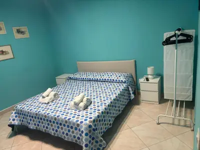 a blue bedroom with a bed with two pillows on it at Casa Vacanze Madison Square in Palermo