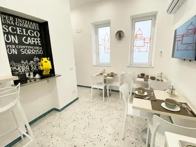 a dining room with white chairs and a table at Dimora Sicula Relais - Palermo in Palermo