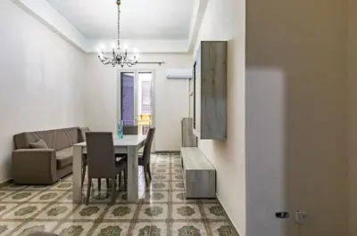 a dining room and living room with a table and chairs at Teatro Massimo Roomy Flat with Covered Terrace in Palermo