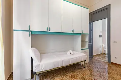 a bedroom with white cabinets and a white bed at Teatro Massimo Roomy Flat with Covered Terrace in Palermo
