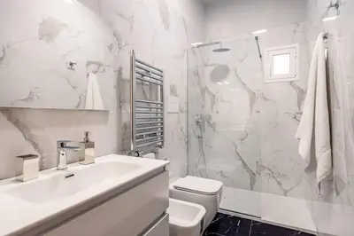 a white bathroom with a sink and a shower at Terrazza San Domenico in Palermo