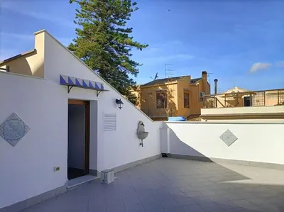 a white building with a door on a patio at Terrazza San Domenico in Palermo