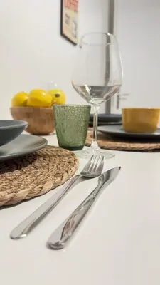 a table with a plate and a glass of wine at Merlo Holiday Homes Siviglia in Palermo