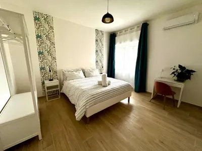 a bedroom with a bed and a table and a window at Merlo Holiday Homes Siviglia in Palermo