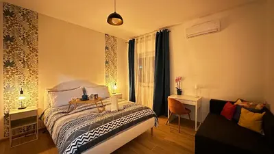 a bedroom with a bed and a desk and a window at Merlo Holiday Homes Siviglia in Palermo