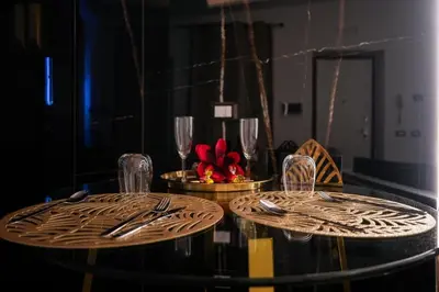 a table with two glasses and a red flower on it at Superior Suite Palermo in Palermo
