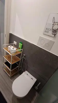 a bathroom with a white toilet in a room at Tati's Garden in Palermo