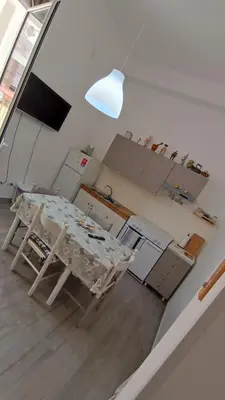 a kitchen with a table and a lamp in it at Tati's Garden in Palermo