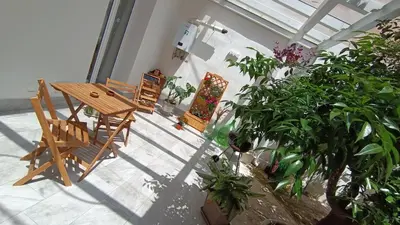 a room with a table and chairs and plants at Tati's Garden in Palermo