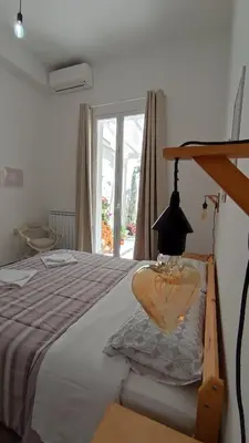 a bedroom with a bed with a lamp and a window at Tati's Garden in Palermo