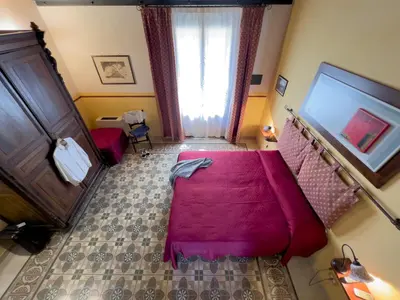 a bedroom with a pink bed and a window at Sicilia Ovest - Domus Mariae Charming Apartments with Balcony in Castellammare del Golfo