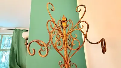 a gold fixture in a bathroom next to a green wall at Donna Isabella a Ballarò in Palermo