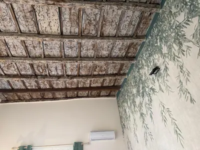 a ceiling in a room with a painting on the wall at Donna Isabella a Ballarò in Palermo