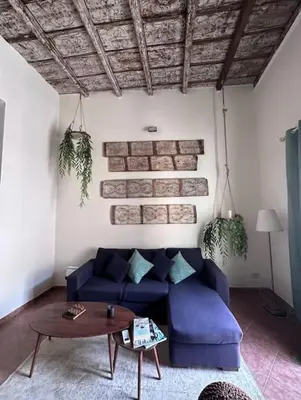 a living room with a blue couch and a table at Donna Isabella a Ballarò in Palermo