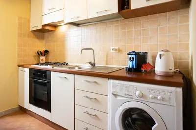 a kitchen with a washing machine and a sink at Hola House allo Spasimo in Palermo