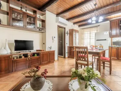 a large living room with a table and a kitchen at CASA VACANZE PERLA in Partinico