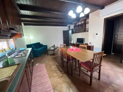a kitchen and living room with a table and chairs at CASA VACANZE PERLA in Partinico
