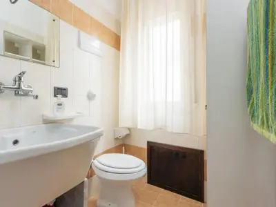 a bathroom with a white toilet and a sink at CASA VACANZE PERLA in Partinico
