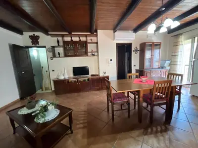 a living room with a table and chairs and a television at CASA VACANZE PERLA in Partinico