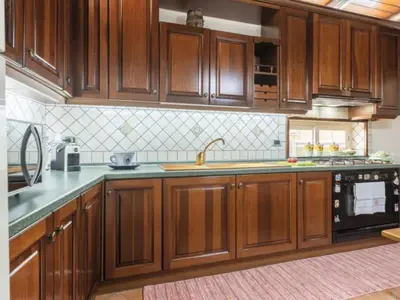 a kitchen with wooden cabinets and a sink at CASA VACANZE PERLA in Partinico