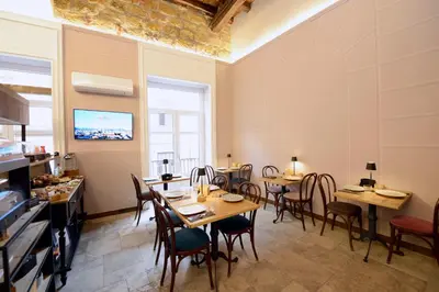 a restaurant with tables and chairs in a room at Heritage Collection Palermo B&B in Palermo