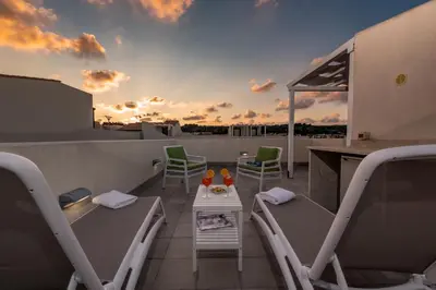 a balcony with chairs and a table on a roof at I Tre Golfi - Villetta Ninfea in San Vito lo Capo