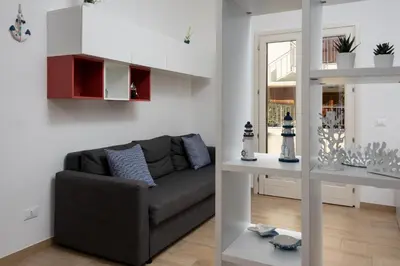 a living room with a couch and a table at I Tre Golfi - Villetta Ninfea in San Vito lo Capo