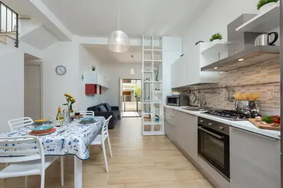 a kitchen with a table and a dining room at I Tre Golfi - Villetta Ninfea in San Vito lo Capo