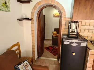 a kitchen with an archway leading into a living room at Holiday House Giorgia in Terrasini
