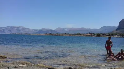 a man and three children standing in the water at Holiday House Giorgia in Terrasini